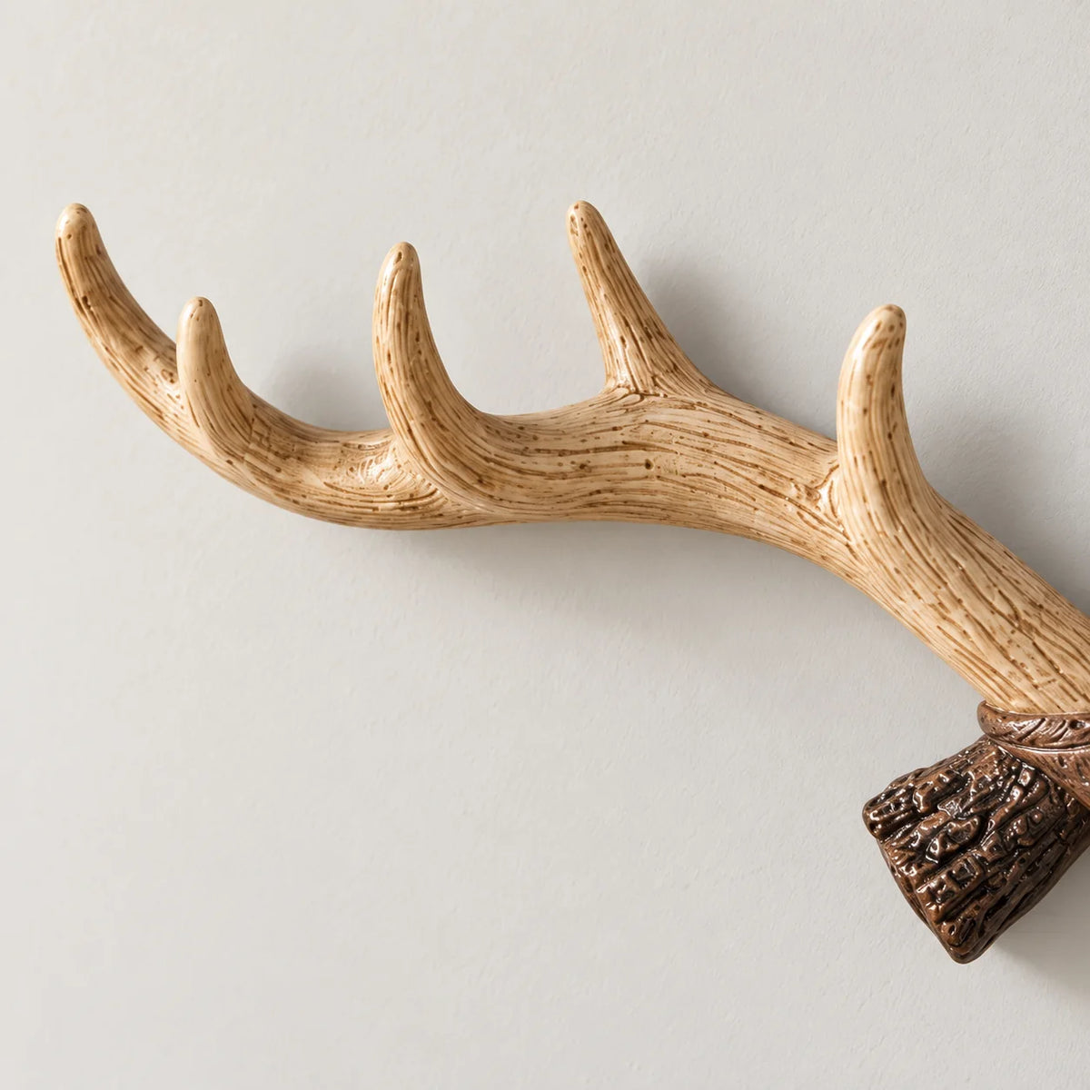Gros plan des pointes incurvées beige clair du porte-manteau mural bois de cerf