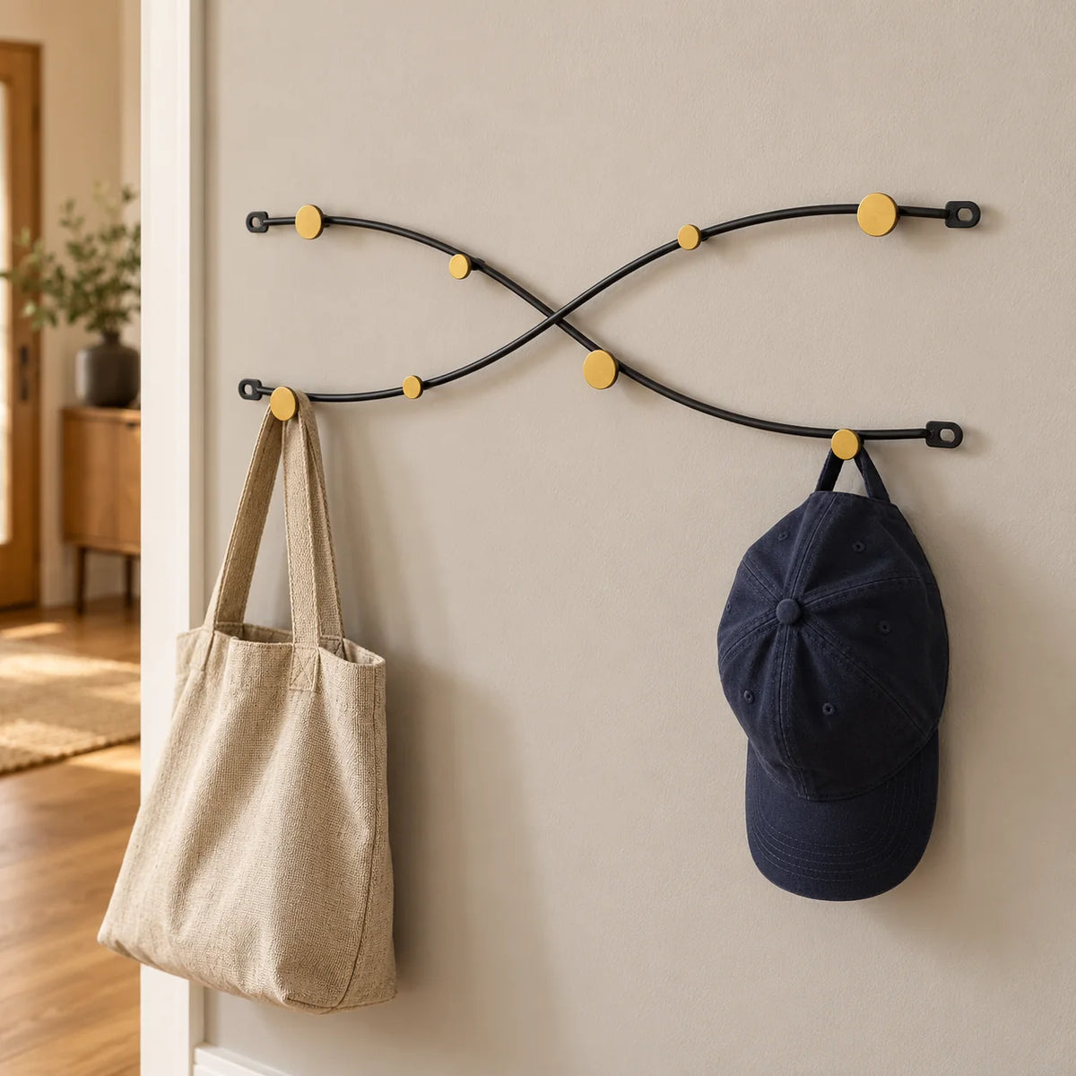 Porte-manteau vague croisée noir dans une entrée avec sac en toile et casquette