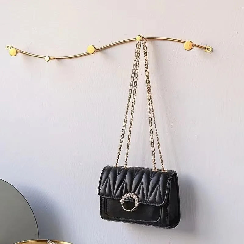 Photo d'origine du porte-manteau mural vague doré avec un sac suspendu