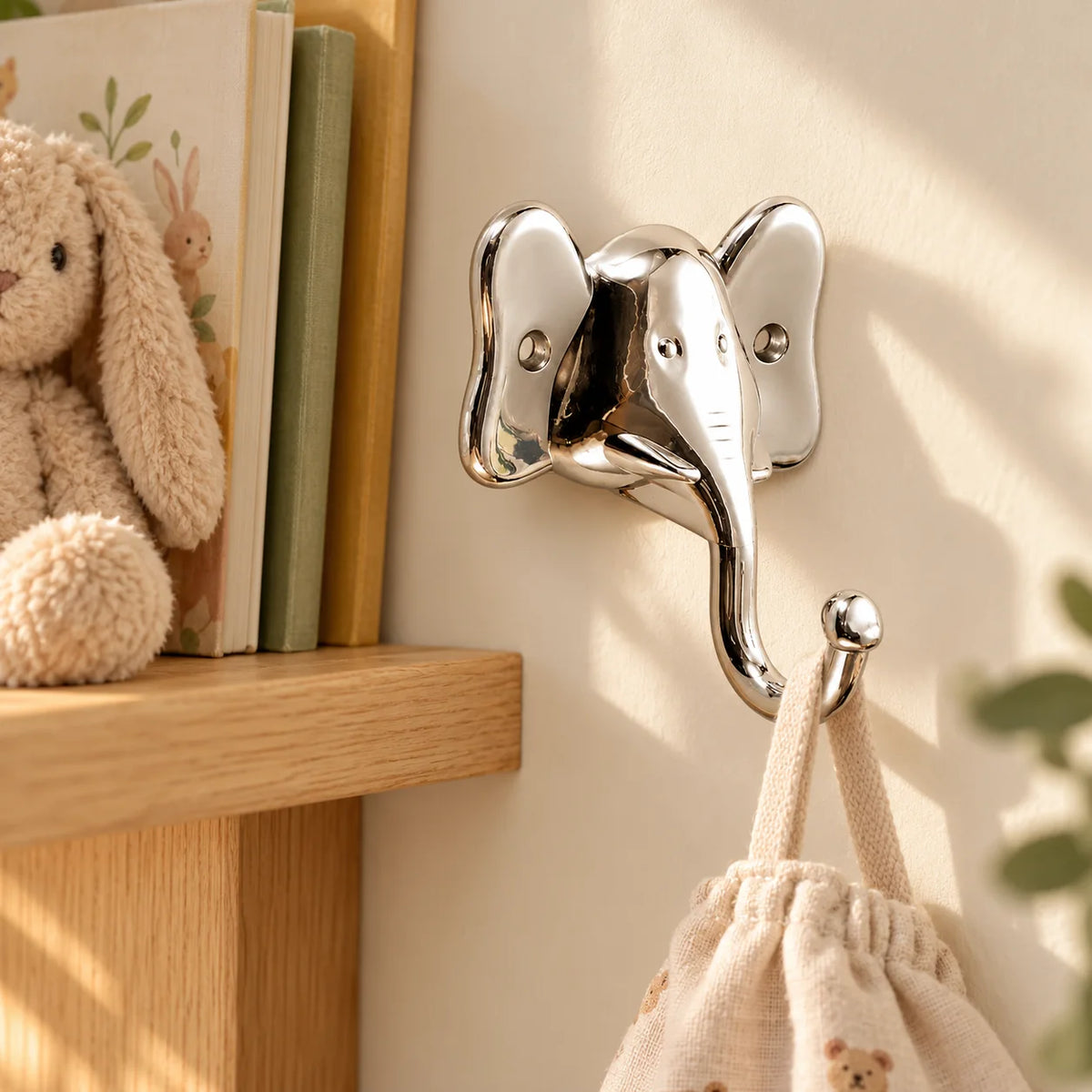 Patère murale éléphant argent dans une chambre d'enfant avec petit sac suspendu