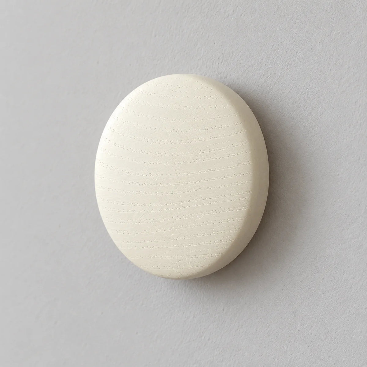 Détail du bois peint blanc et du bord arrondi de la patère