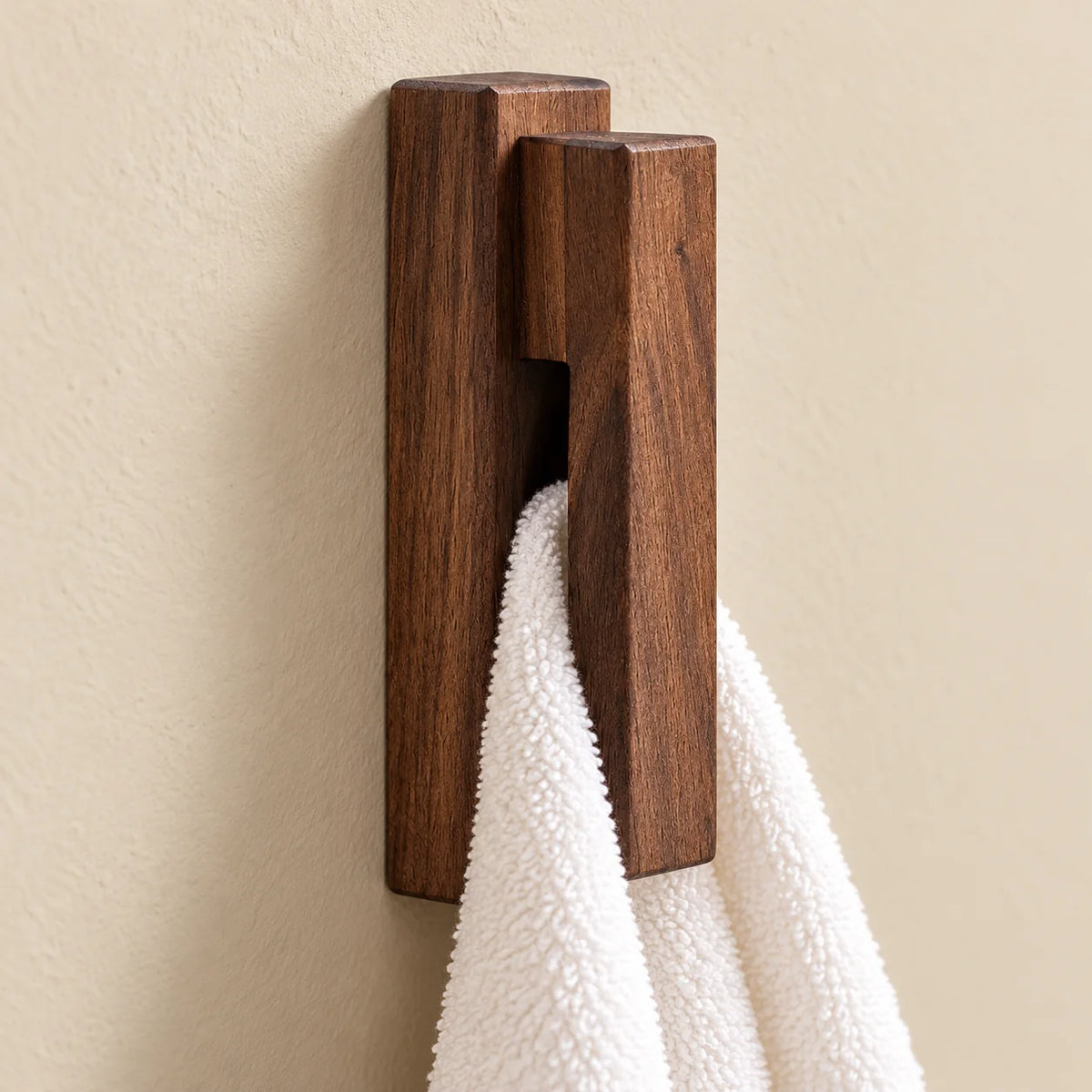 Gros plan de la fente verticale d’une patère en noyer foncé avec serviette
