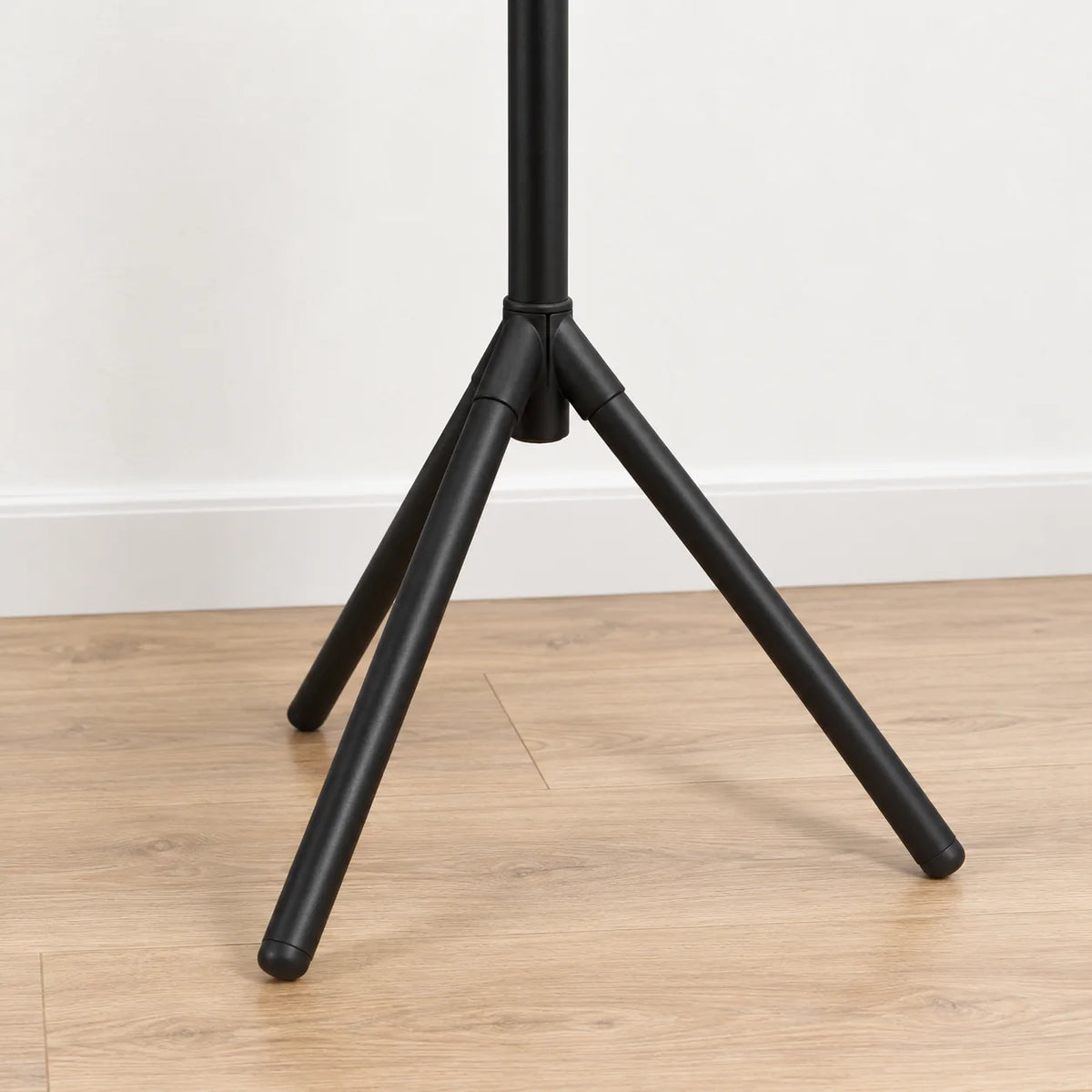 Détail de la base à trois pieds du porte-manteau noir