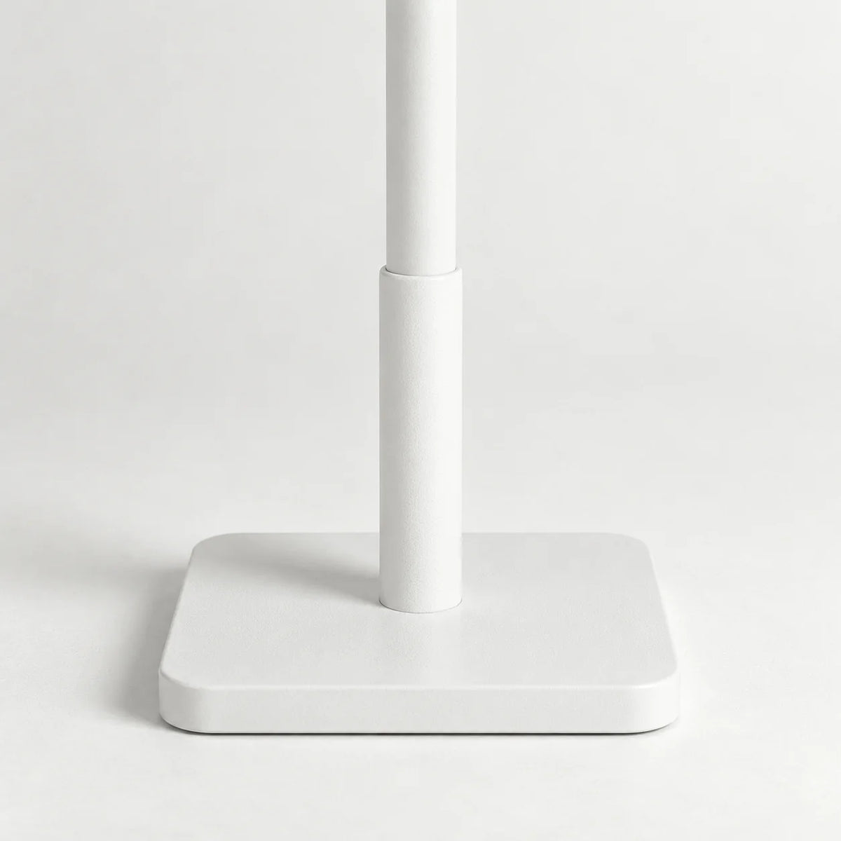 Gros plan sur le pied carré blanc et le mât du porte-manteau arbre sur pied