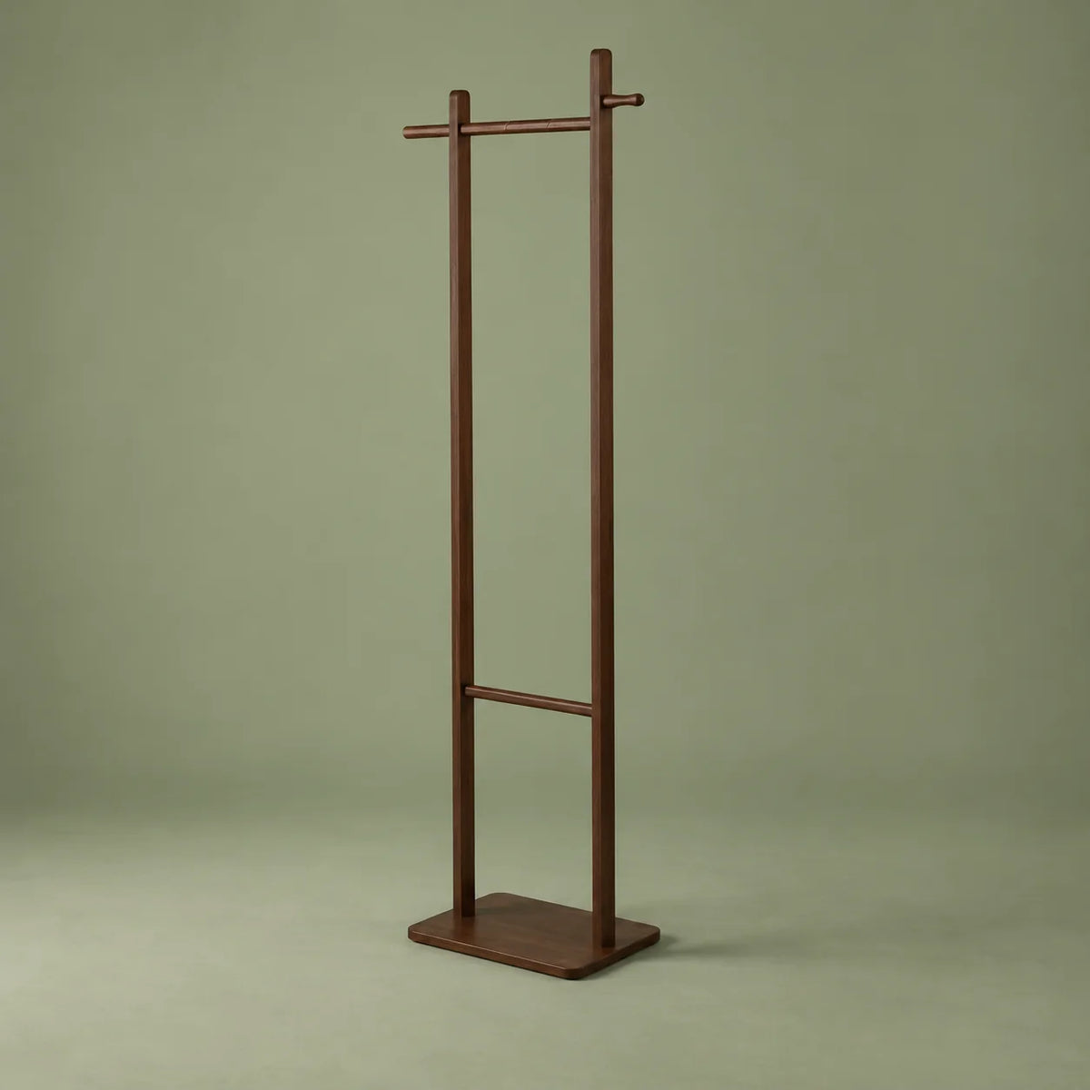 Vue entière de trois quarts du porte-manteau sur pied en bois foncé sur fond vert sauge