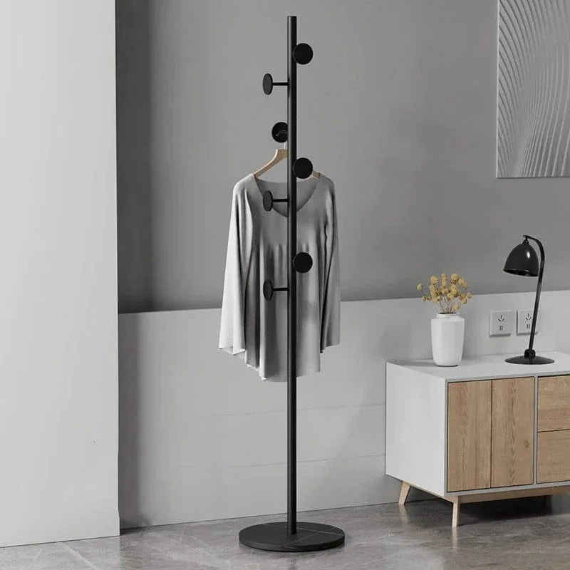 Porte-manteau champignon noir avec manteau gris dans un intérieur, photo originale
