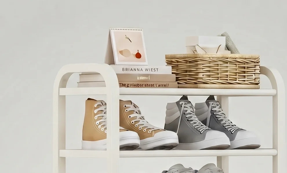 Détail du plateau supérieur de l’étagère blanche avec livres, petit cadre et panier en osier