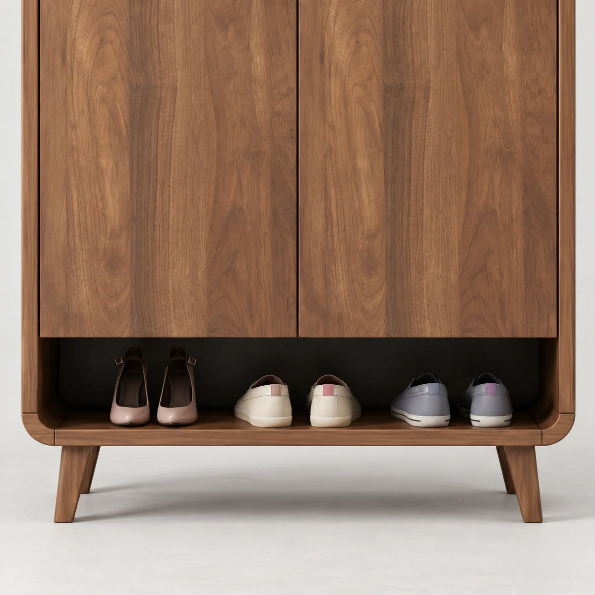 Détail de la niche basse ouverte et des pieds en bois du meuble à chaussures