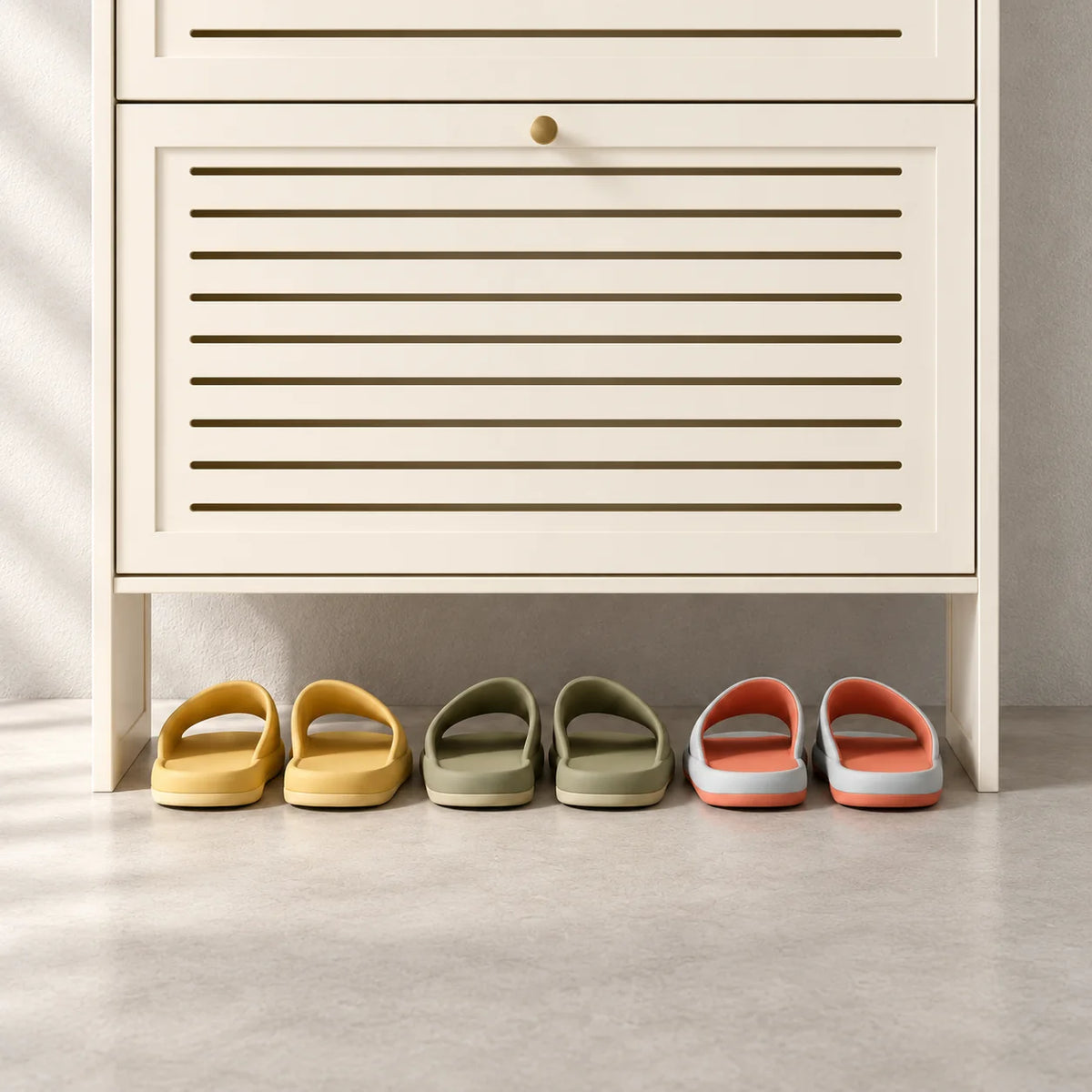 Détail de la façade basse blanc crème et de la niche avec trois paires de chaussons