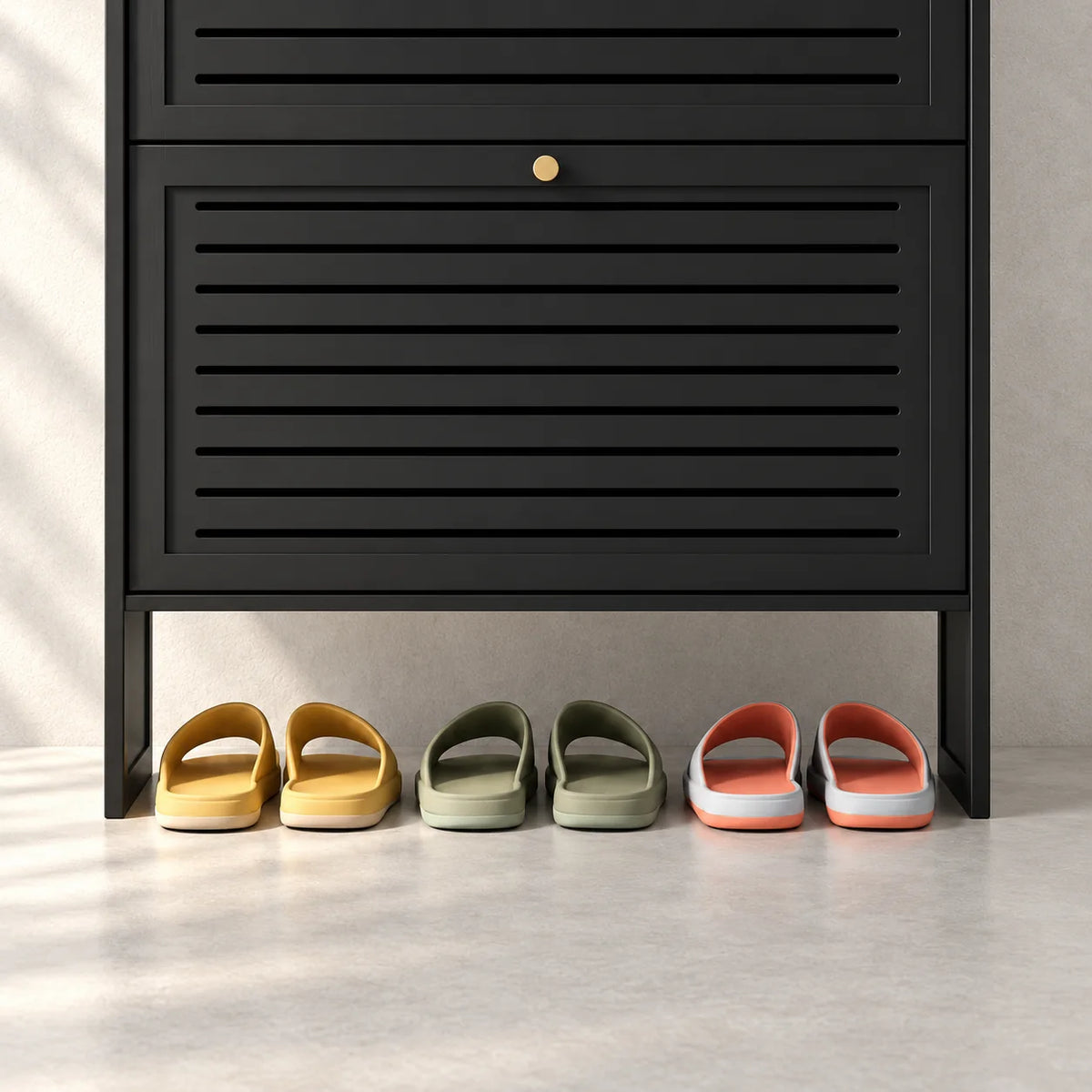 Détail de la façade basse noire et de la niche avec trois paires de chaussons
