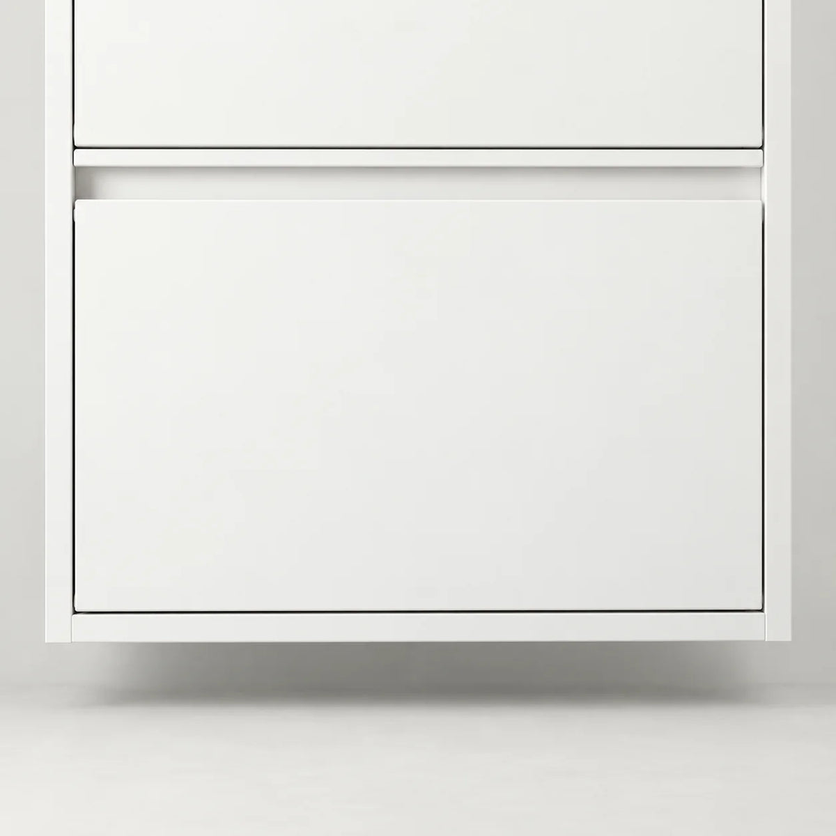 Détail de la façade inférieure et du bord suspendu du meuble à chaussures blanc