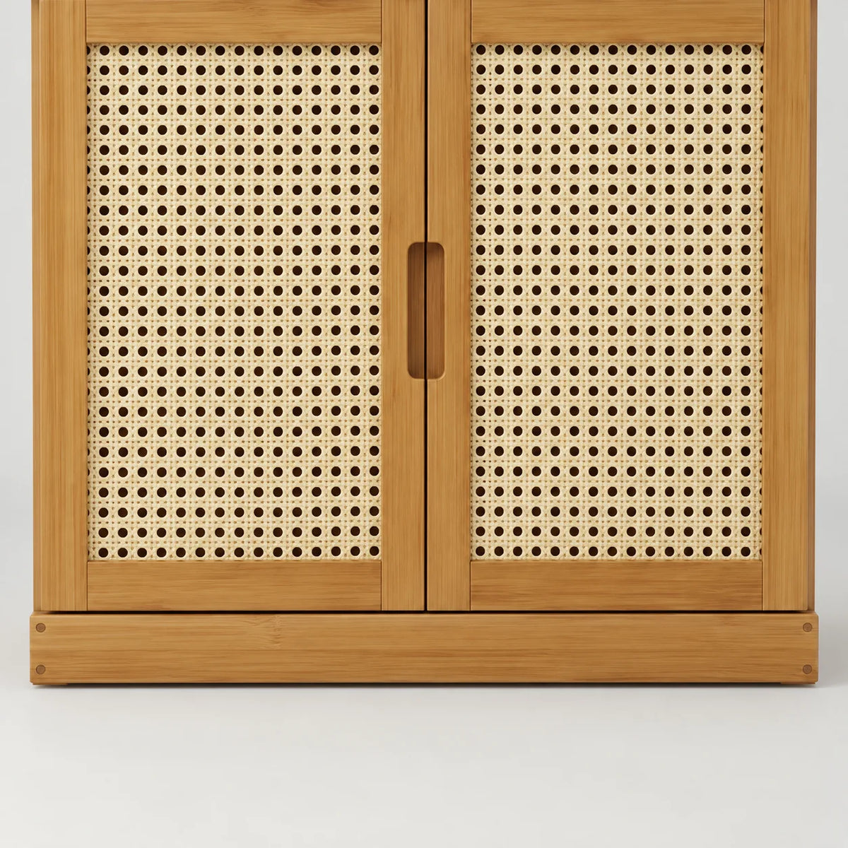 Détail des deux portes en cannage et du socle bas en bambou du meuble à chaussures