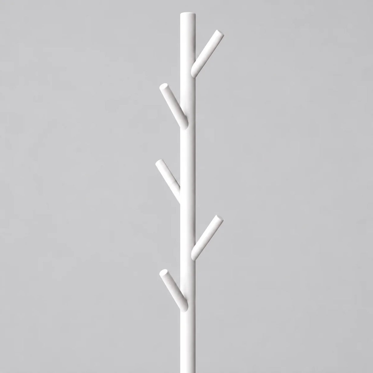 Gros plan des patères en branches blanches du porte-manteau arbre sur pied blanc