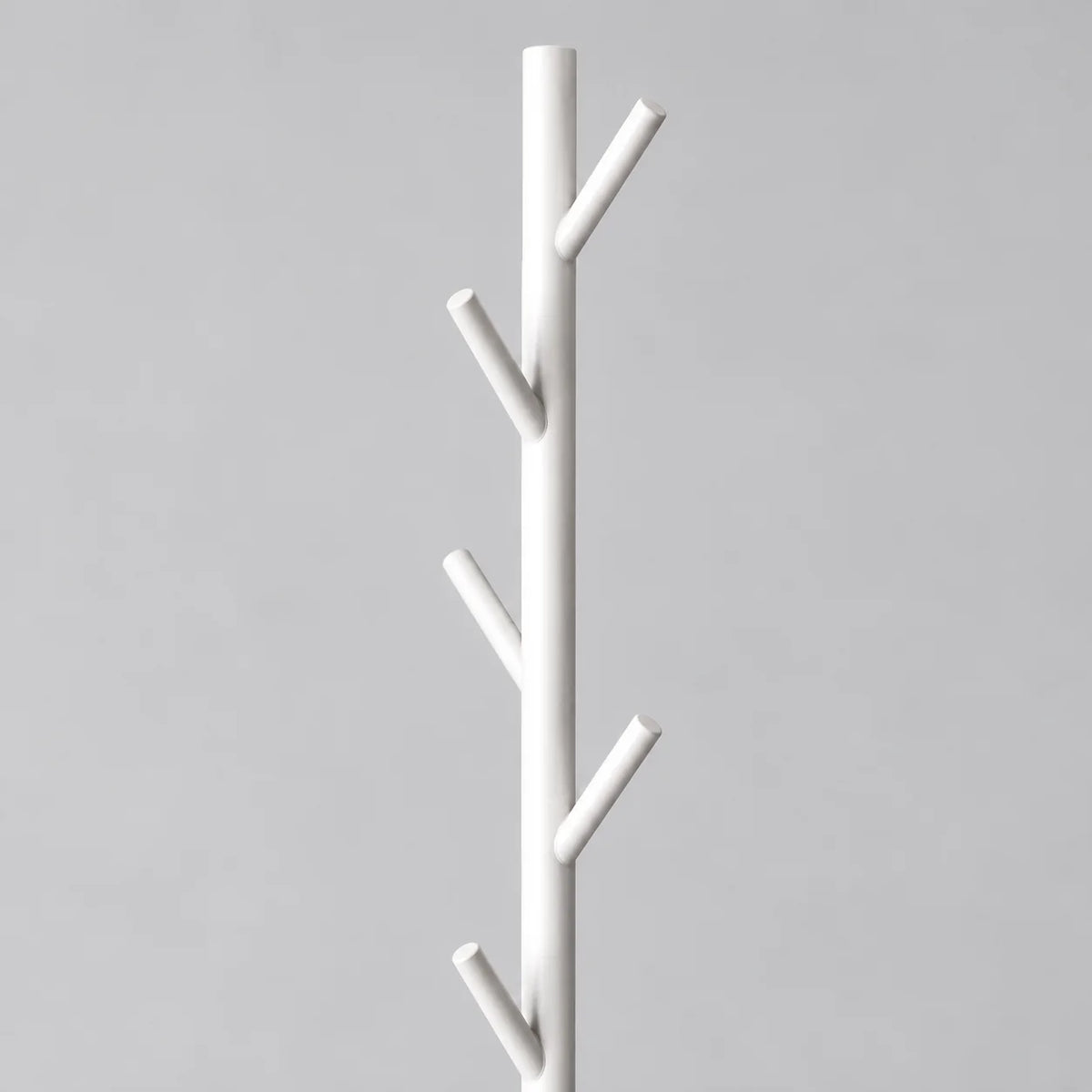 Gros plan des patères en branches blanches du porte-manteau arbre