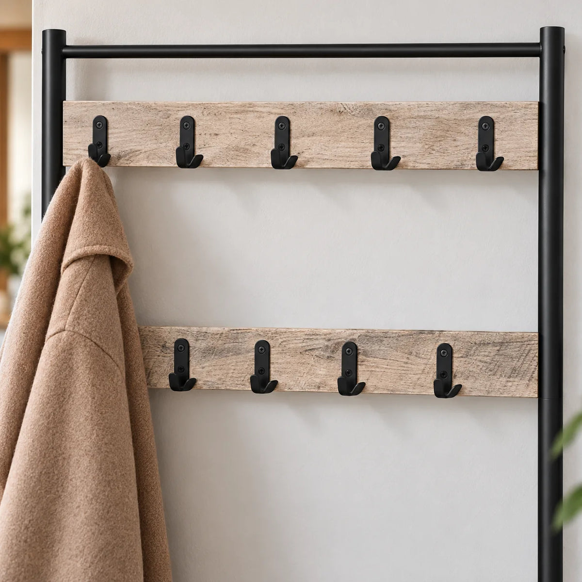 Détail des deux rangées de patères noires sur lattes en bois beige