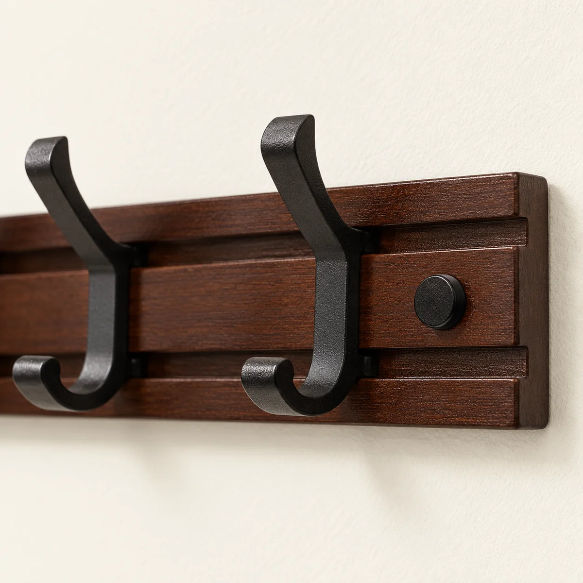Détail de la planche rainurée en bois foncé et des crochets noirs