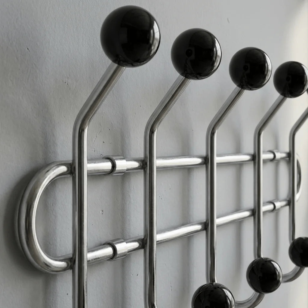 Détail original des boules noires brillantes et bras chromés du porte-manteau