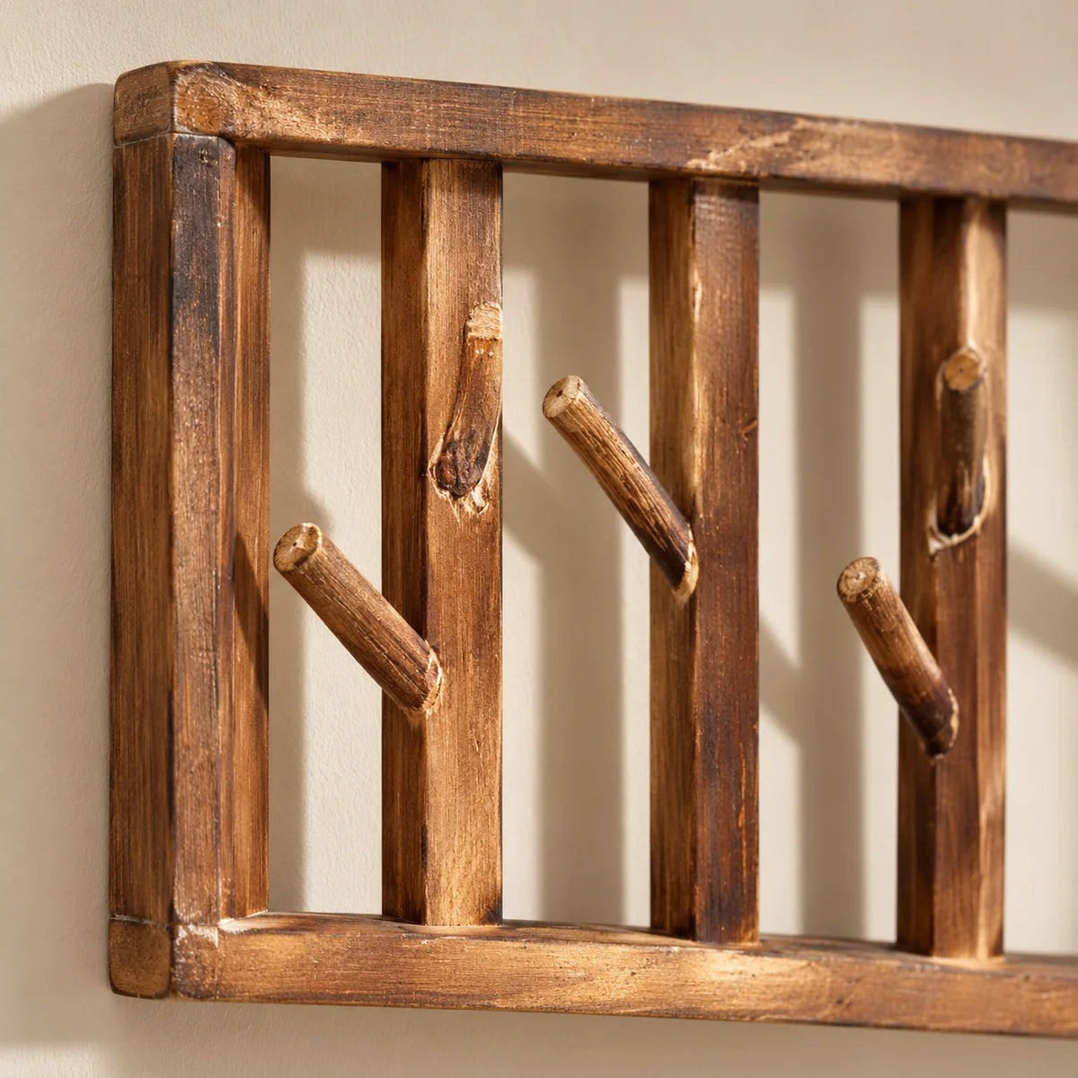 Gros plan des crochets en bois branchage et du cadre gauche du porte-manteau Tige Bois