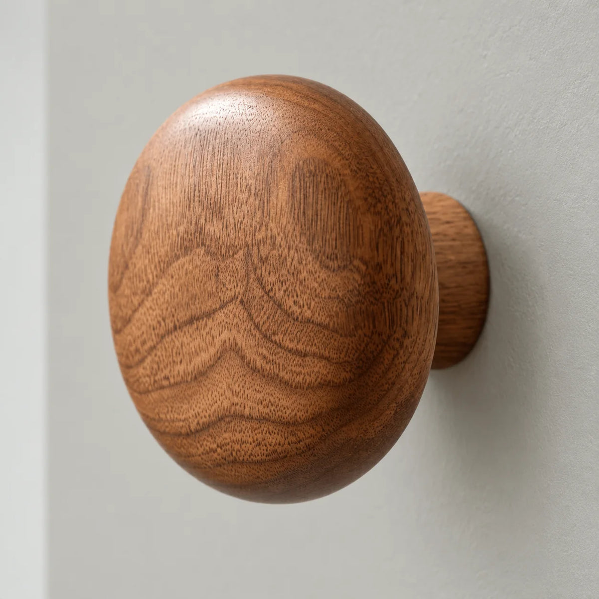 Gros plan du veinage de la patère murale ronde en bois brun
