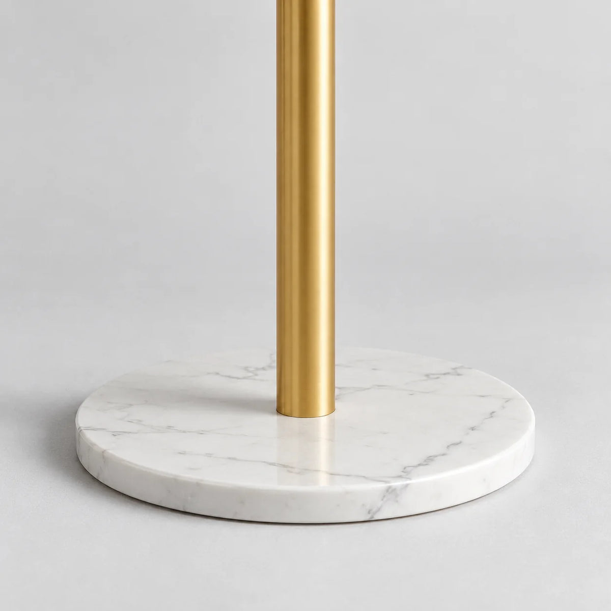 Détail de la base ronde blanche effet marbre et du mât métallique doré