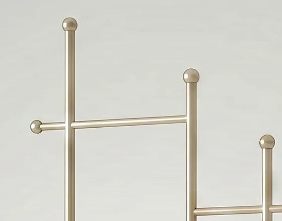 Détail de la traverse supérieure dorée, des montants hauts et des embouts sphériques du porte-manteau