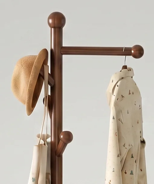 Détail de la boule supérieure, de la traverse en bois marron et du chapeau suspendu sur la patère