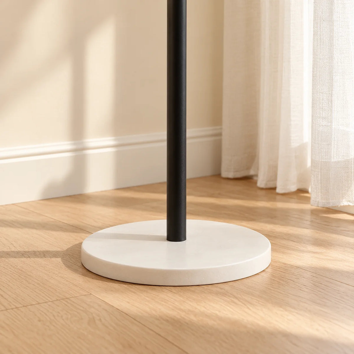 Détail du pied noir et du socle rond blanc du porte-manteau Nuage
