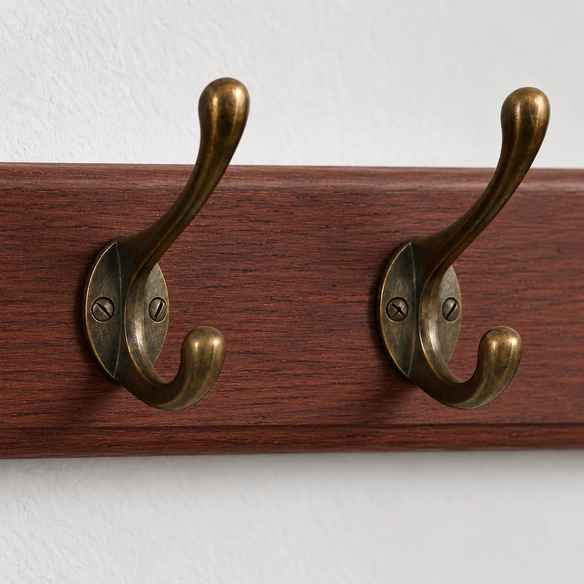Détail des crochets anciens en bronze vieilli vissés sur le bois foncé du Porte Manteau entrée Ancien Grand Crochet bois