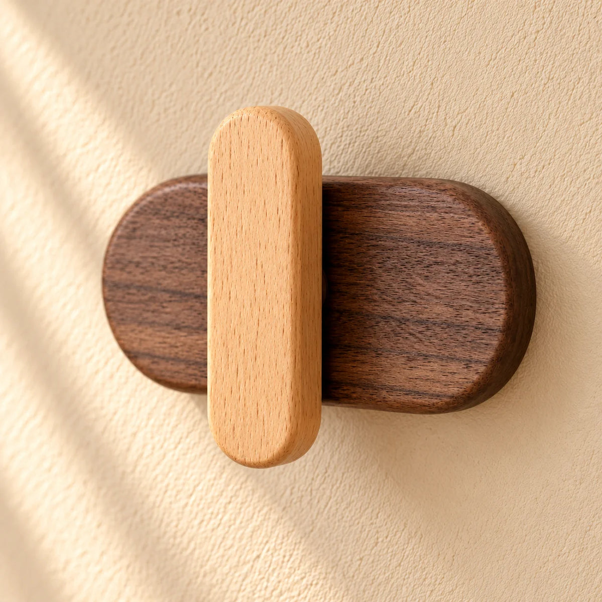 Détail en léger angle du crochet clair et de sa base ovale en bois foncé