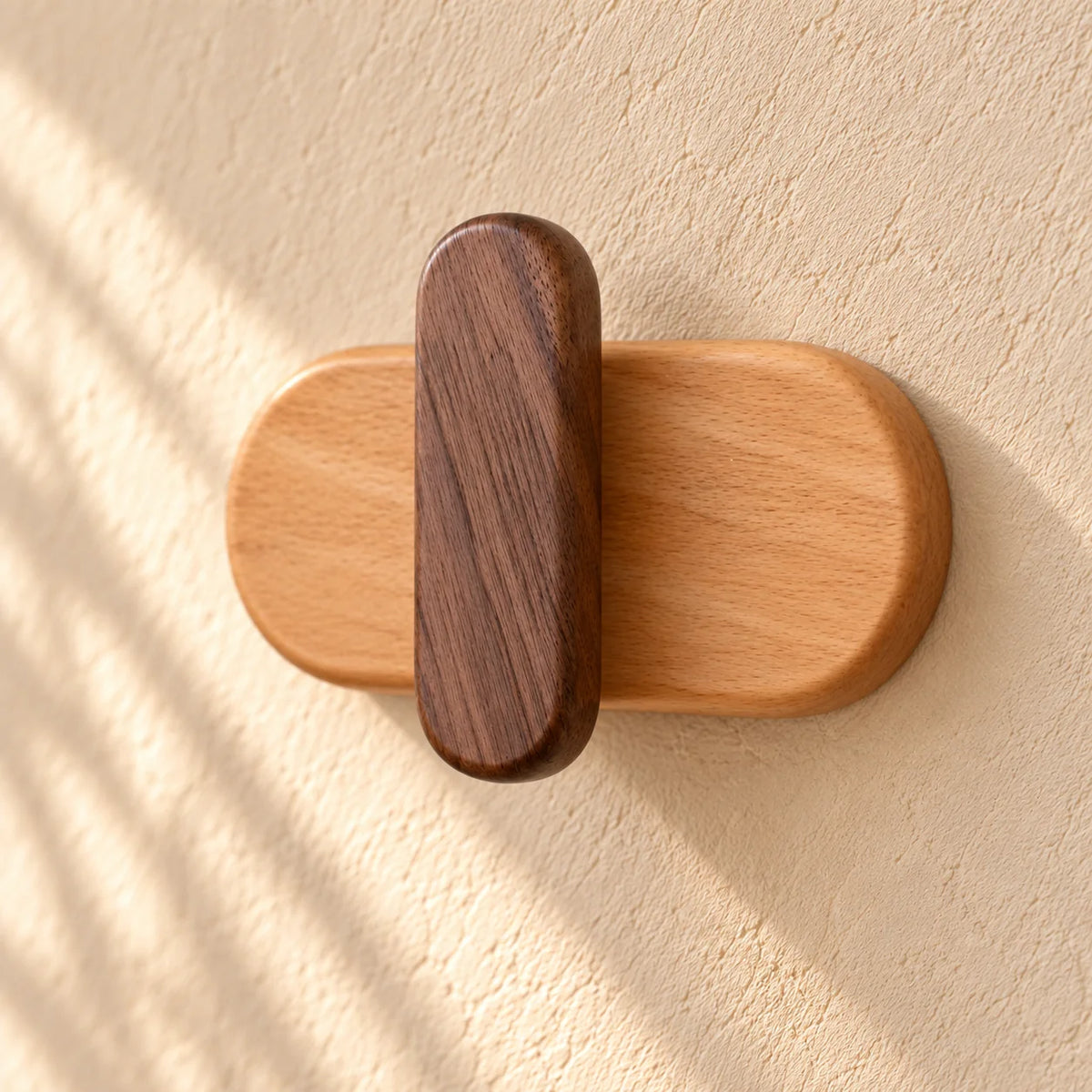 Détail en léger angle du crochet foncé et de sa base ovale en bois clair