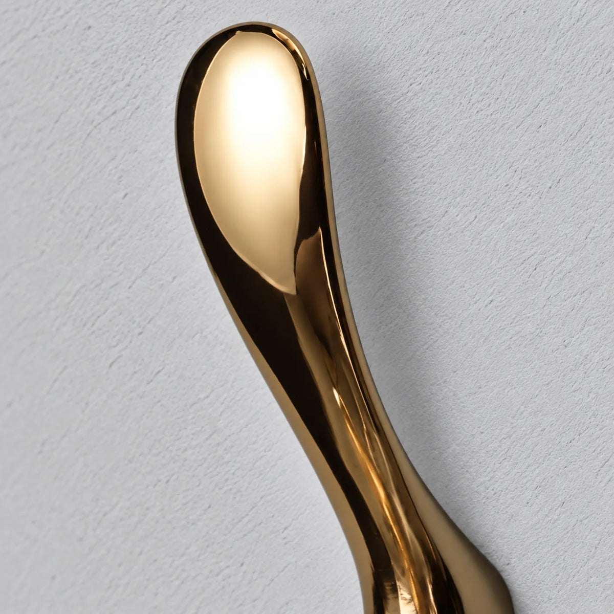 Gros plan de la partie supérieure sculptée de la patère dorée brillante