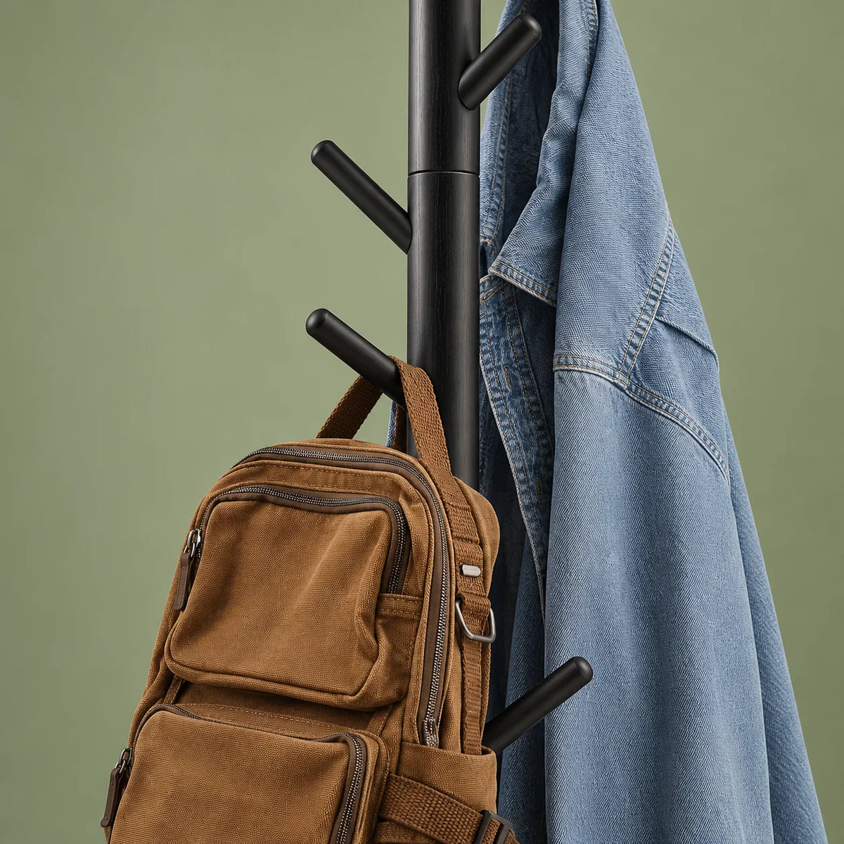 Détail des branches noires médianes portant un sac à dos brun et une veste en jean