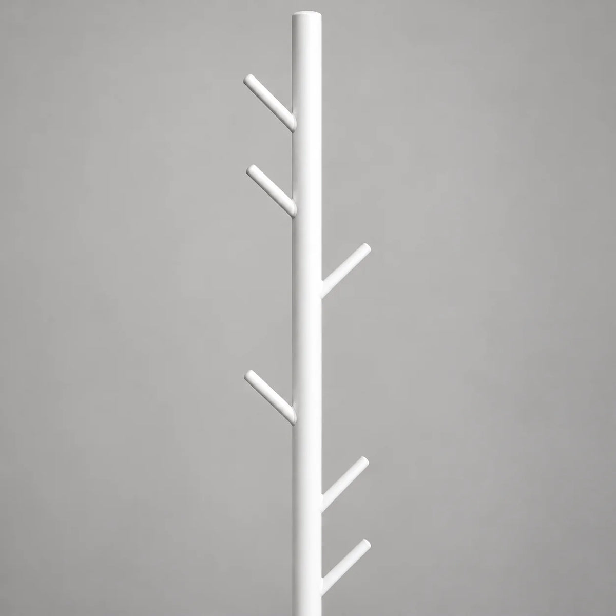 Gros plan des patères inclinées en métal blanc du porte-manteau arbre