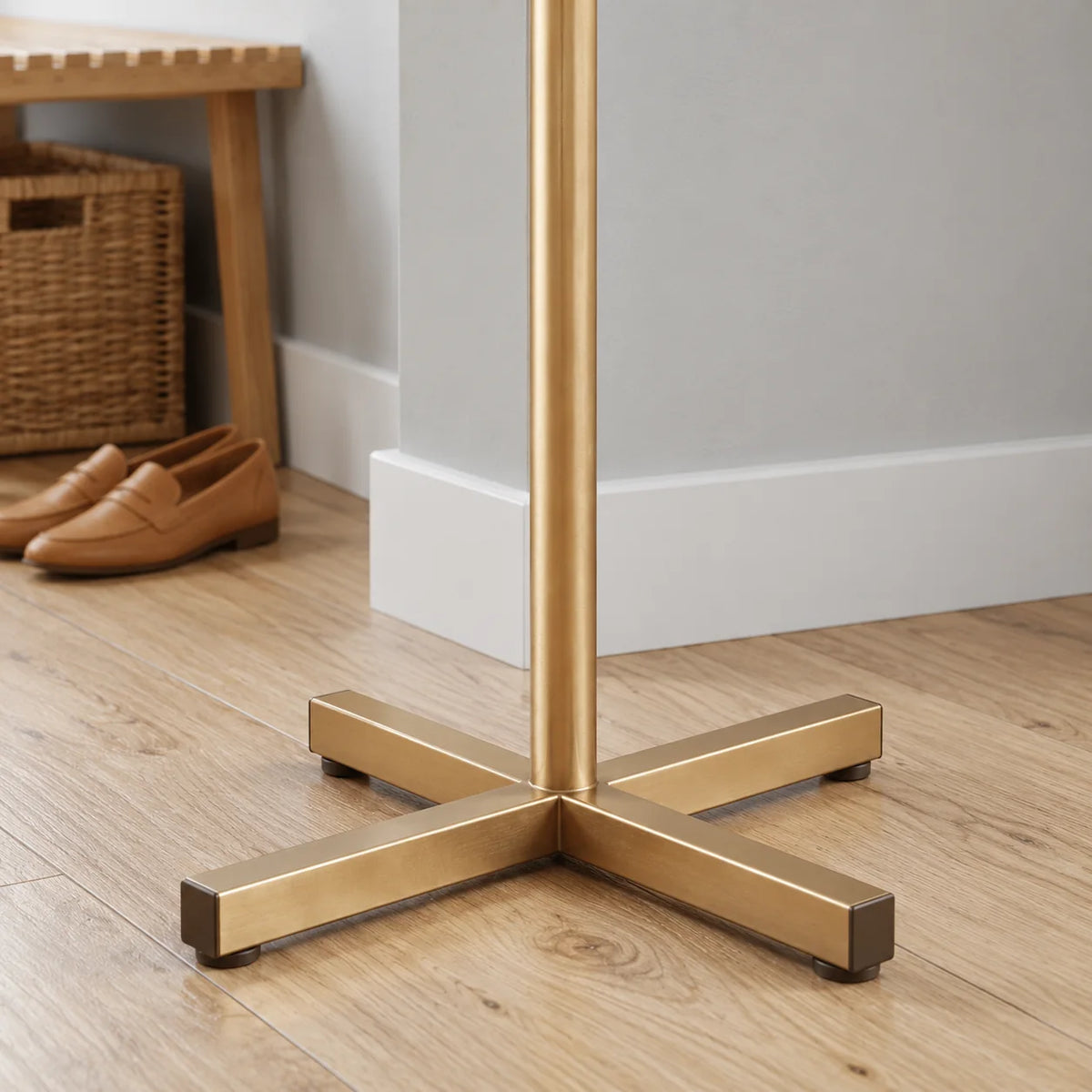 Gros plan du pied à quatre branches croisées du porte-manteau doré