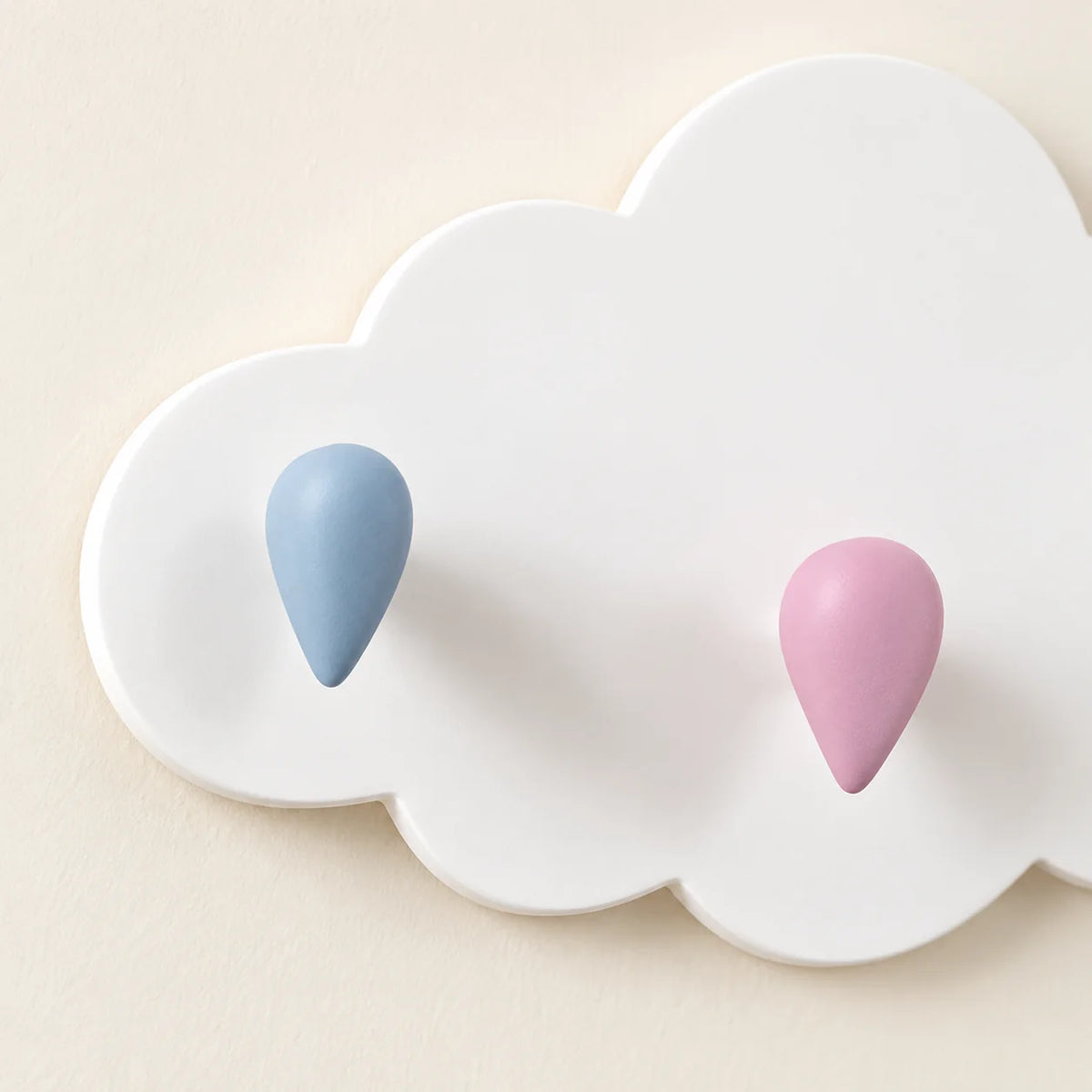 Gros plan des patères goutte bleue et rose en relief sur le nuage blanc