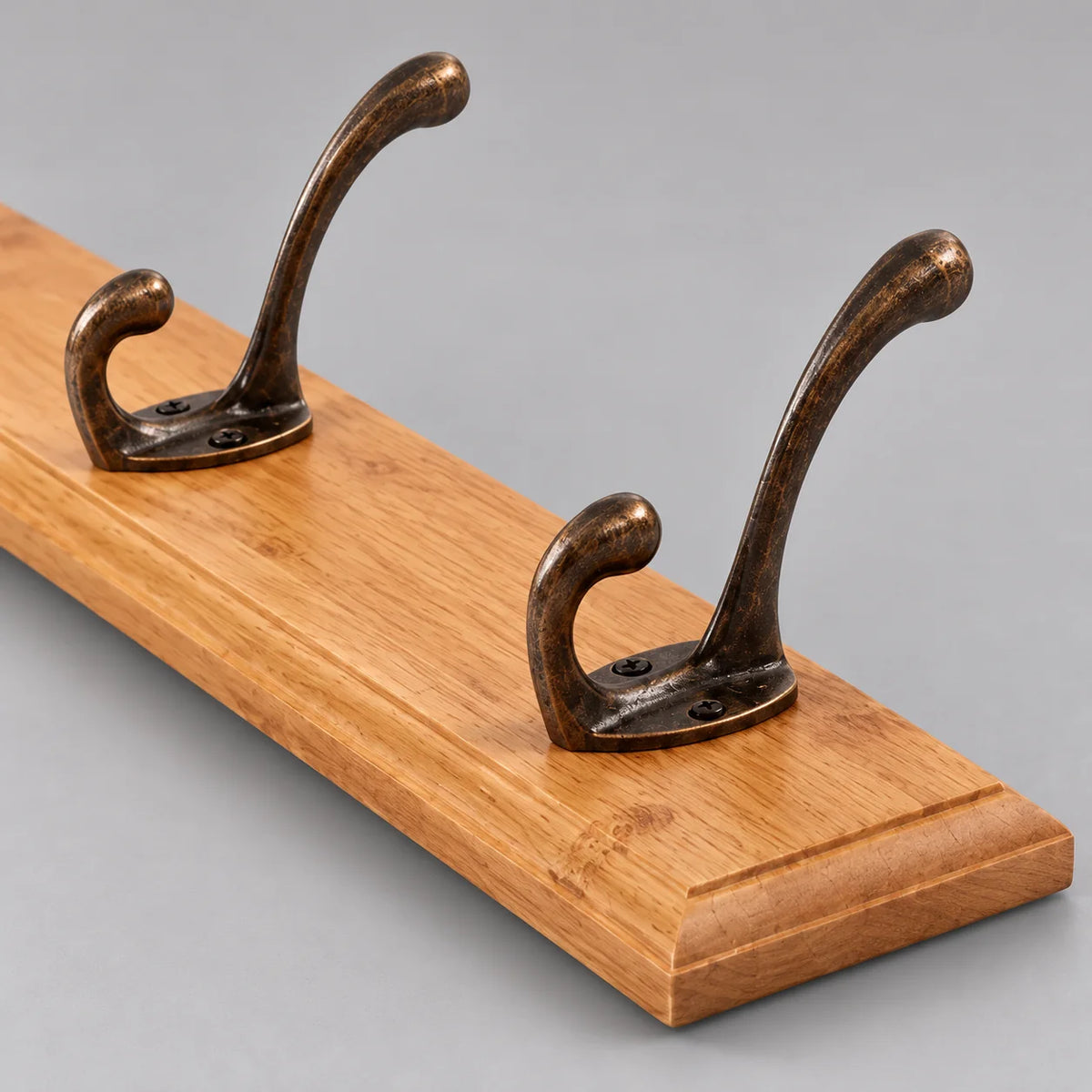 Détail du chant de la planche en bois clair et de deux crochets doubles
