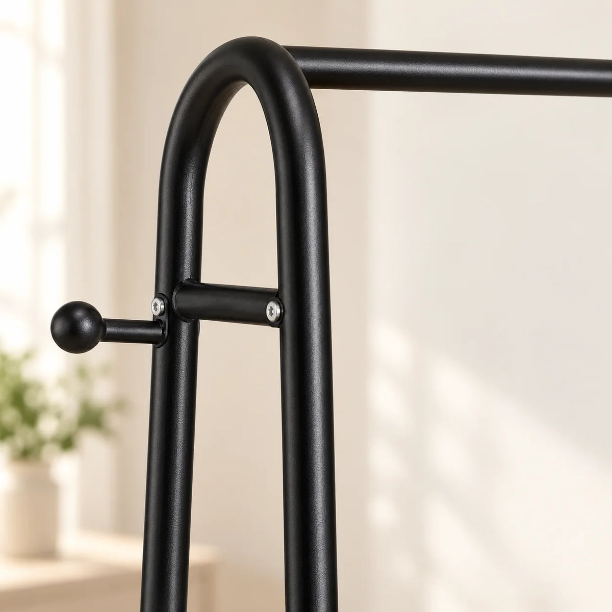 Gros plan de l’arche en métal noir, de la barre et de la patère latérale du mini dressing