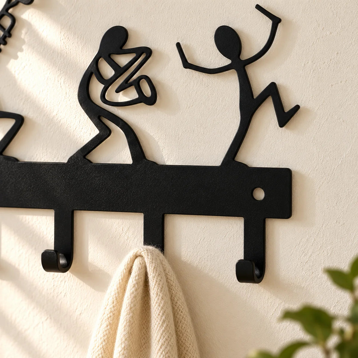 Gros plan des deux silhouettes de droite et des crochets en métal noir