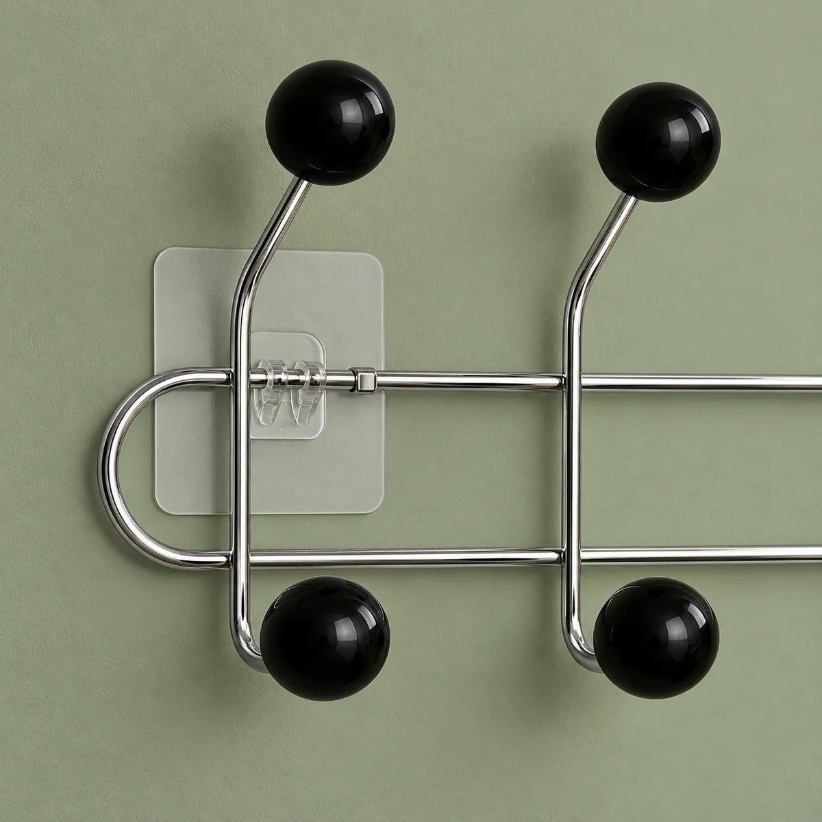 Gros plan des boules noires, tubes chromés et fixation transparente sur fond vert