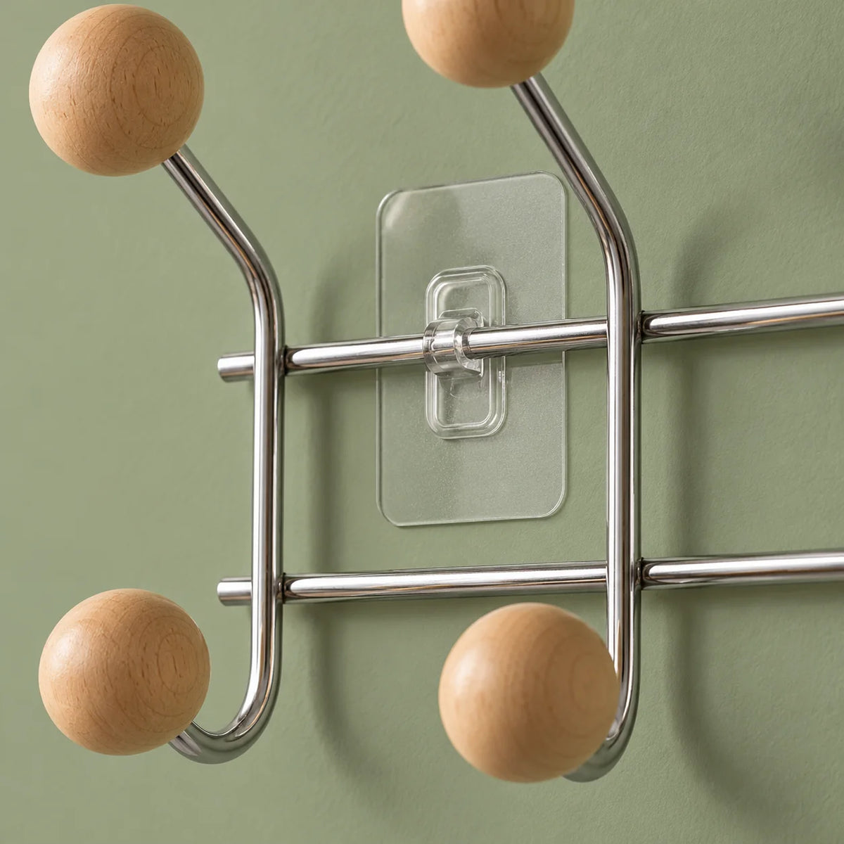 Gros plan des boules en bois, tubes chromés et fixation transparente sur fond vert