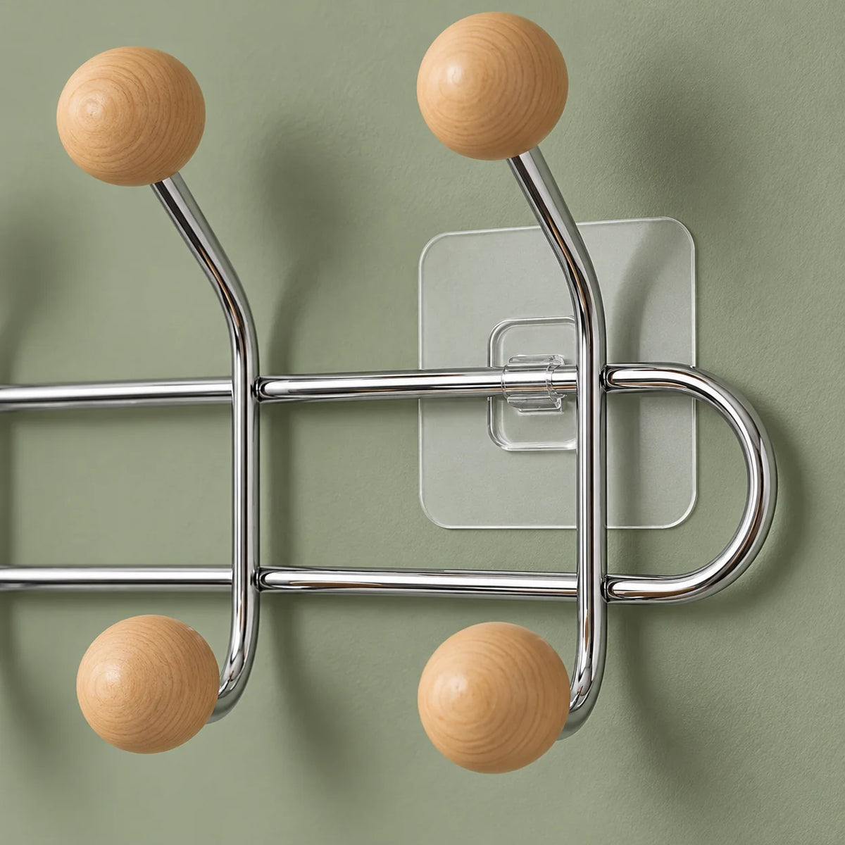 Gros plan des boules en bois, tubes chromés et fixation transparente sur fond vert