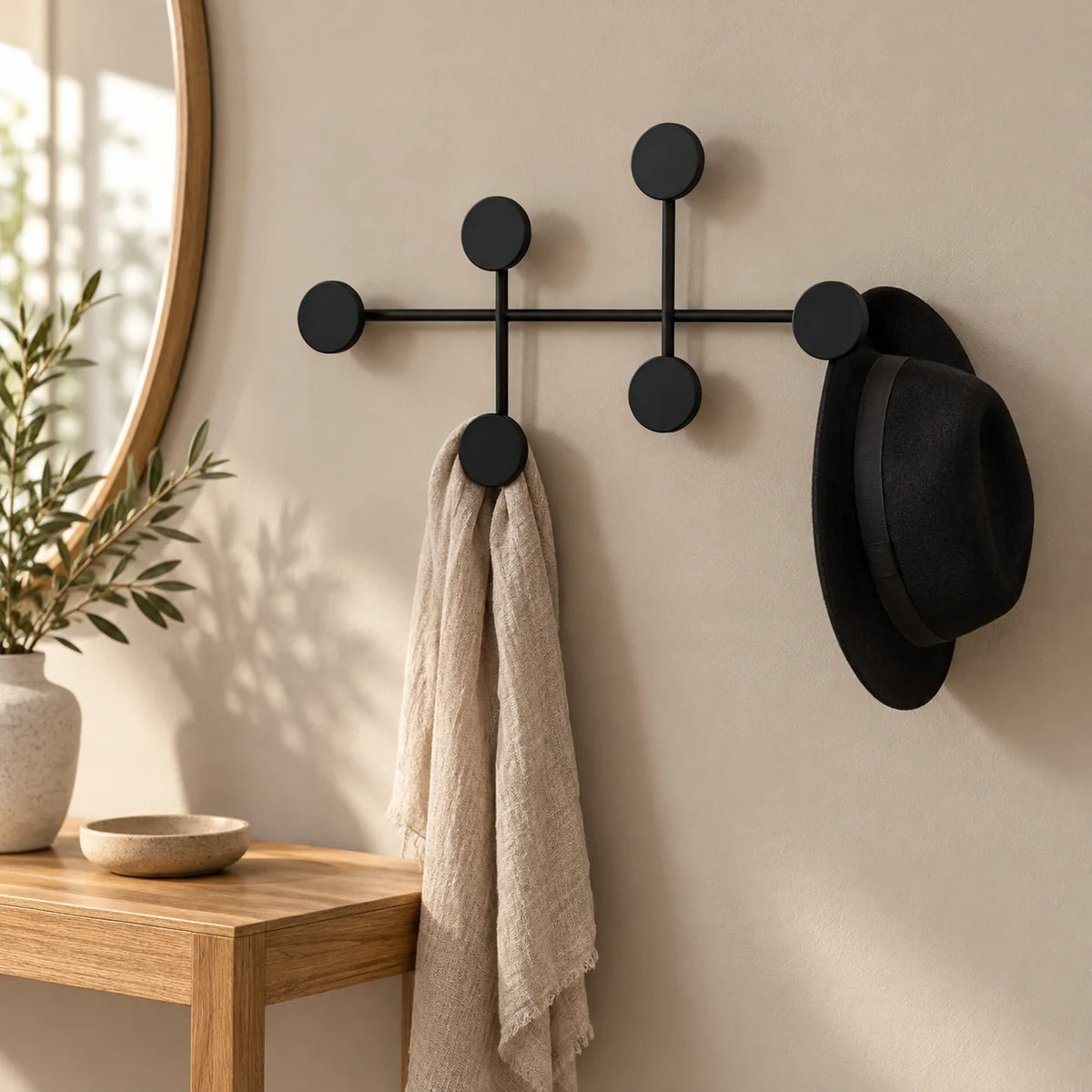 Porte-manteau mural rond noir dans une entrée au-dessus d'une console en chêne