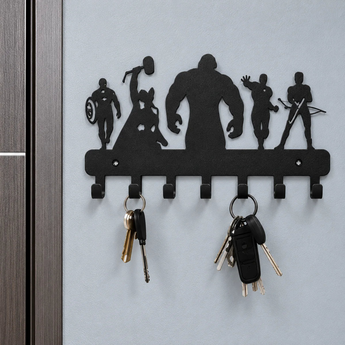 Gros plan des silhouettes décoratives et des sept crochets de la patère murale noire