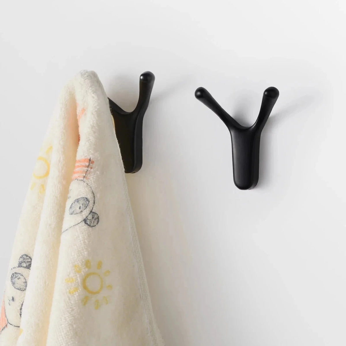 Photo originale de patères Antenne noires fixées au mur avec linge suspendu