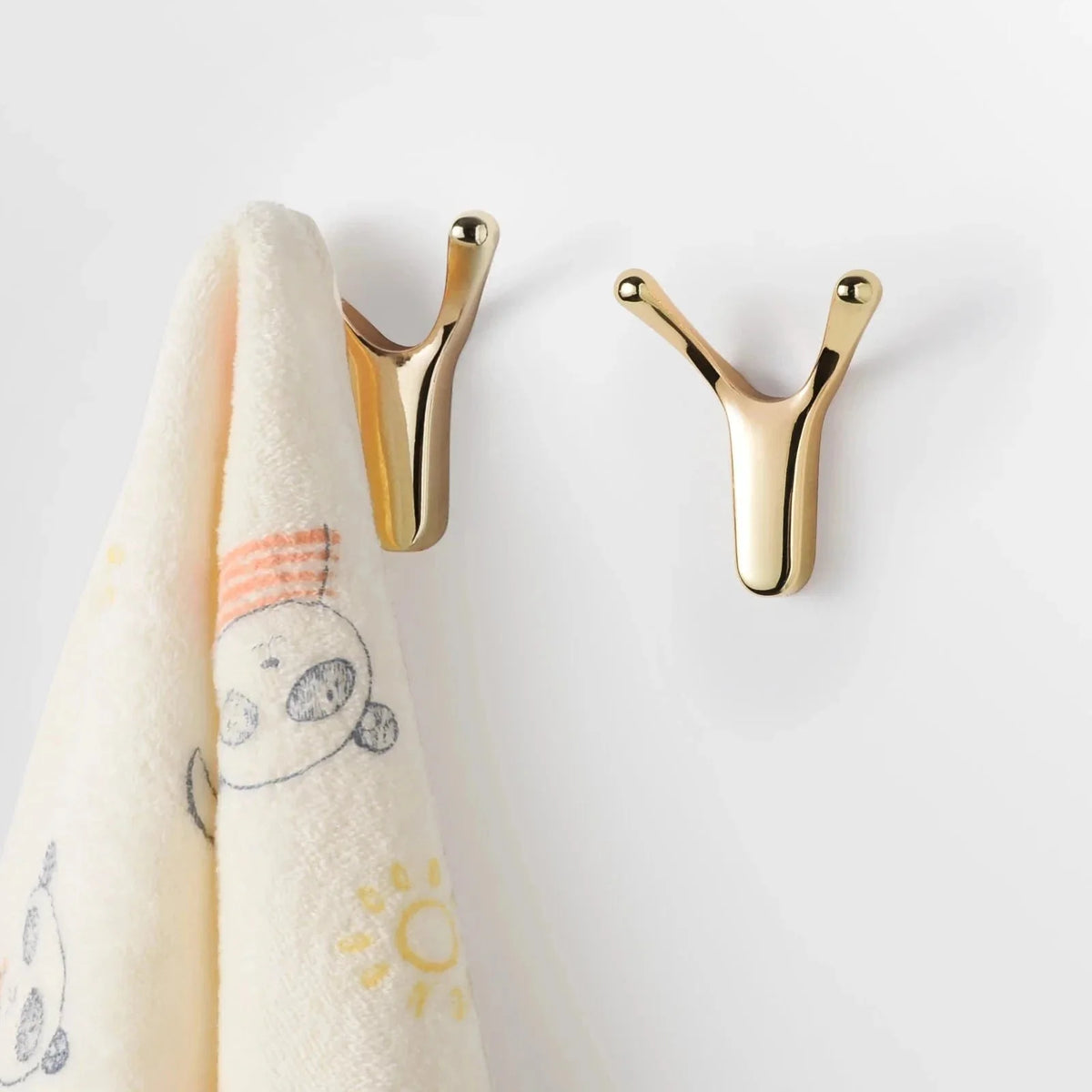 Photo originale de patères Antenne dorées fixées au mur avec linge suspendu