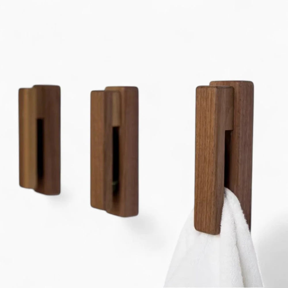 Trois patères à barrette en bois foncé dont une avec serviette