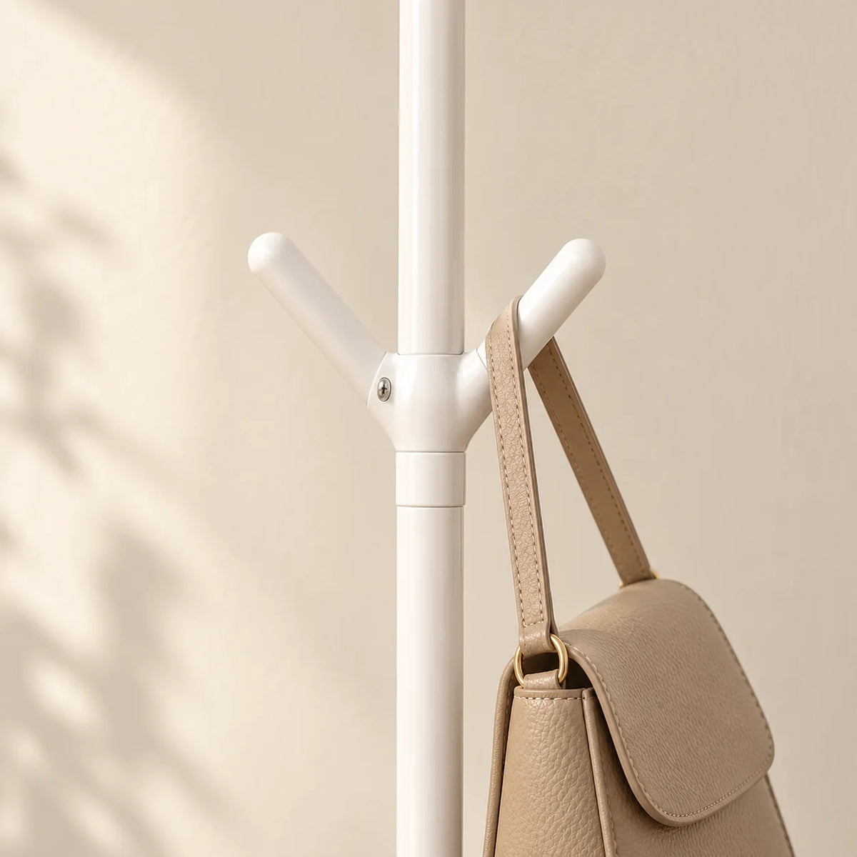 Détail des crochets intermédiaires blancs portant un sac beige