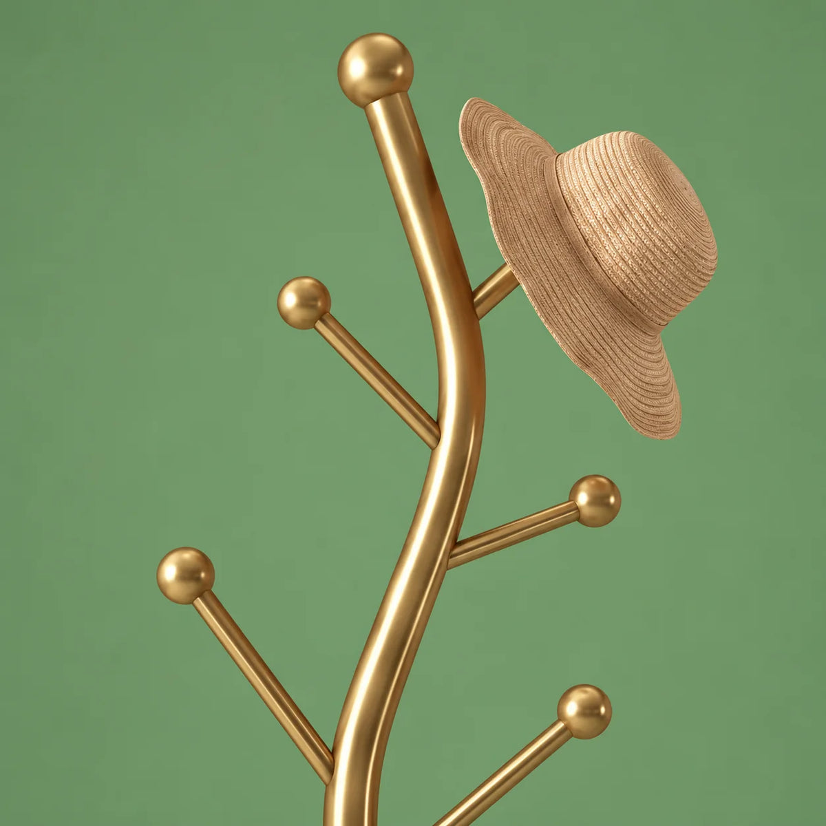 Détail du sommet arborescent doré, des embouts ronds et du chapeau de paille beige sur fond vert sauge