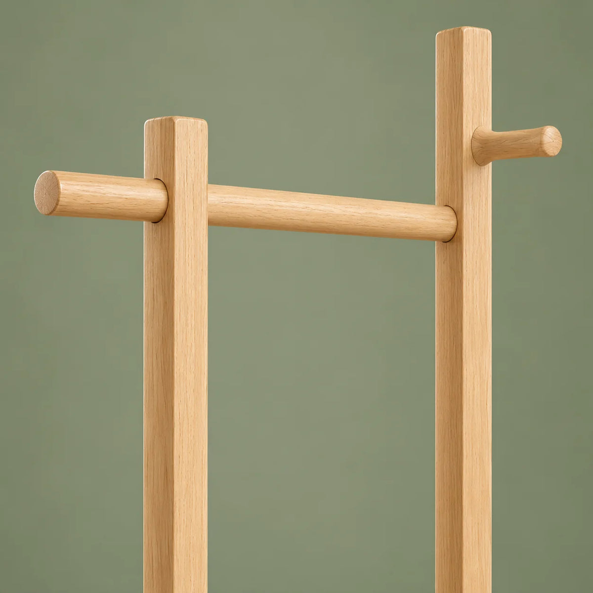 Détail de la barre haute et du crochet en bois clair du porte-manteau sur pied