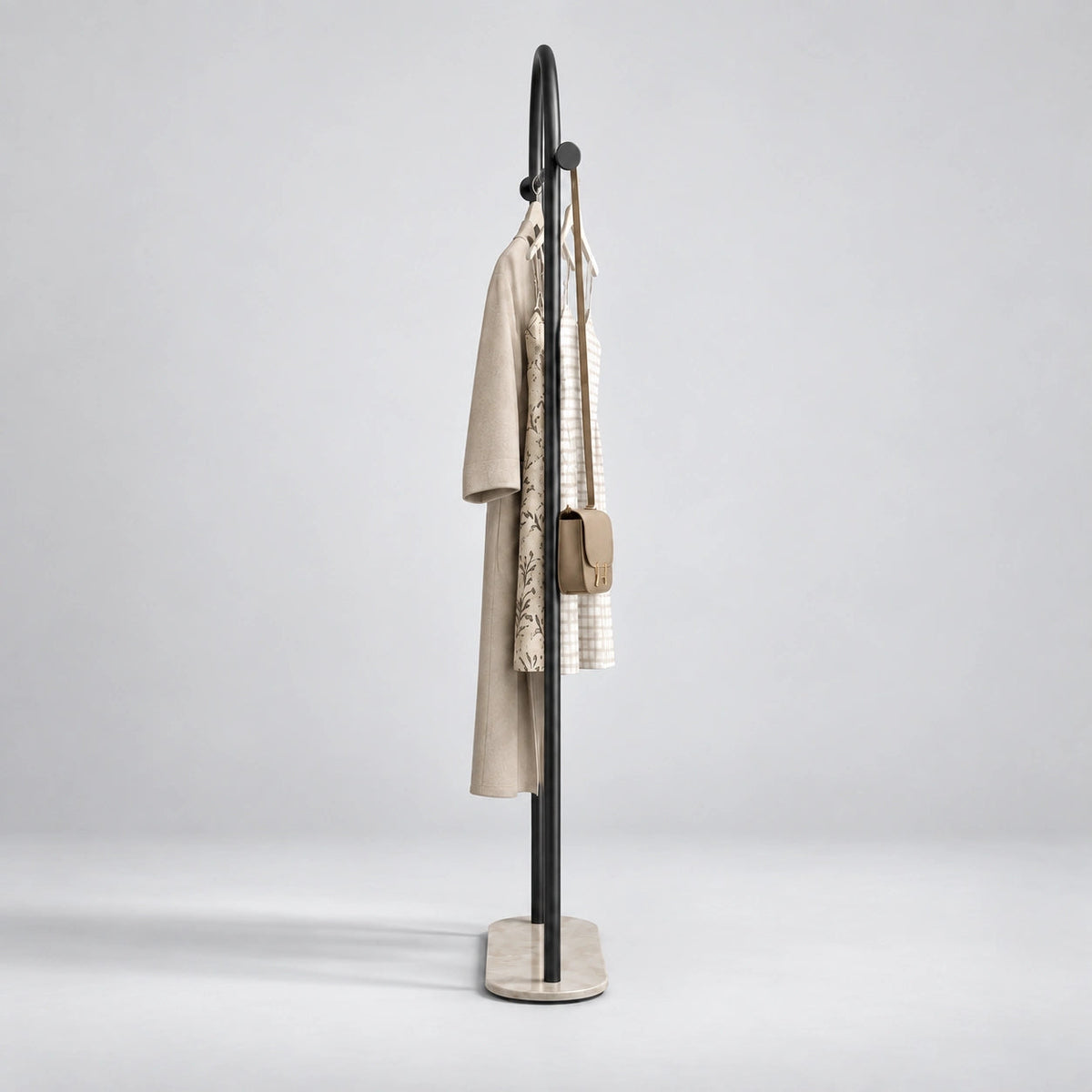 Porte Manteau sur Pied Courbé noir vu de profil, structure fine en métal noir sur fond studio